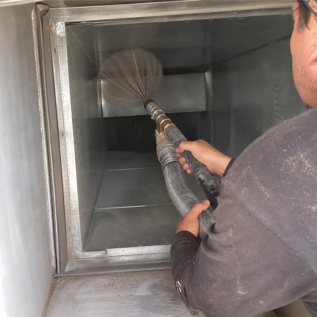 Technician using rotary brush tool for professional air duct cleaning service